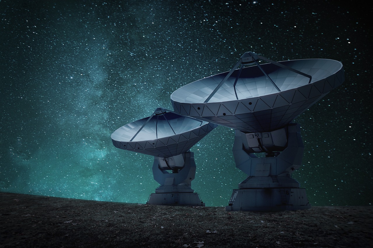 two radio telescopes with a stary night in the background