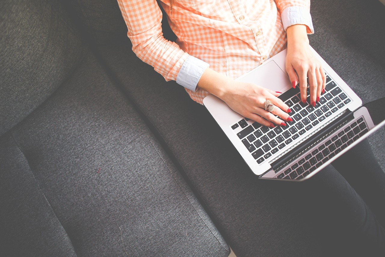 person sat on a sofa with a laptop